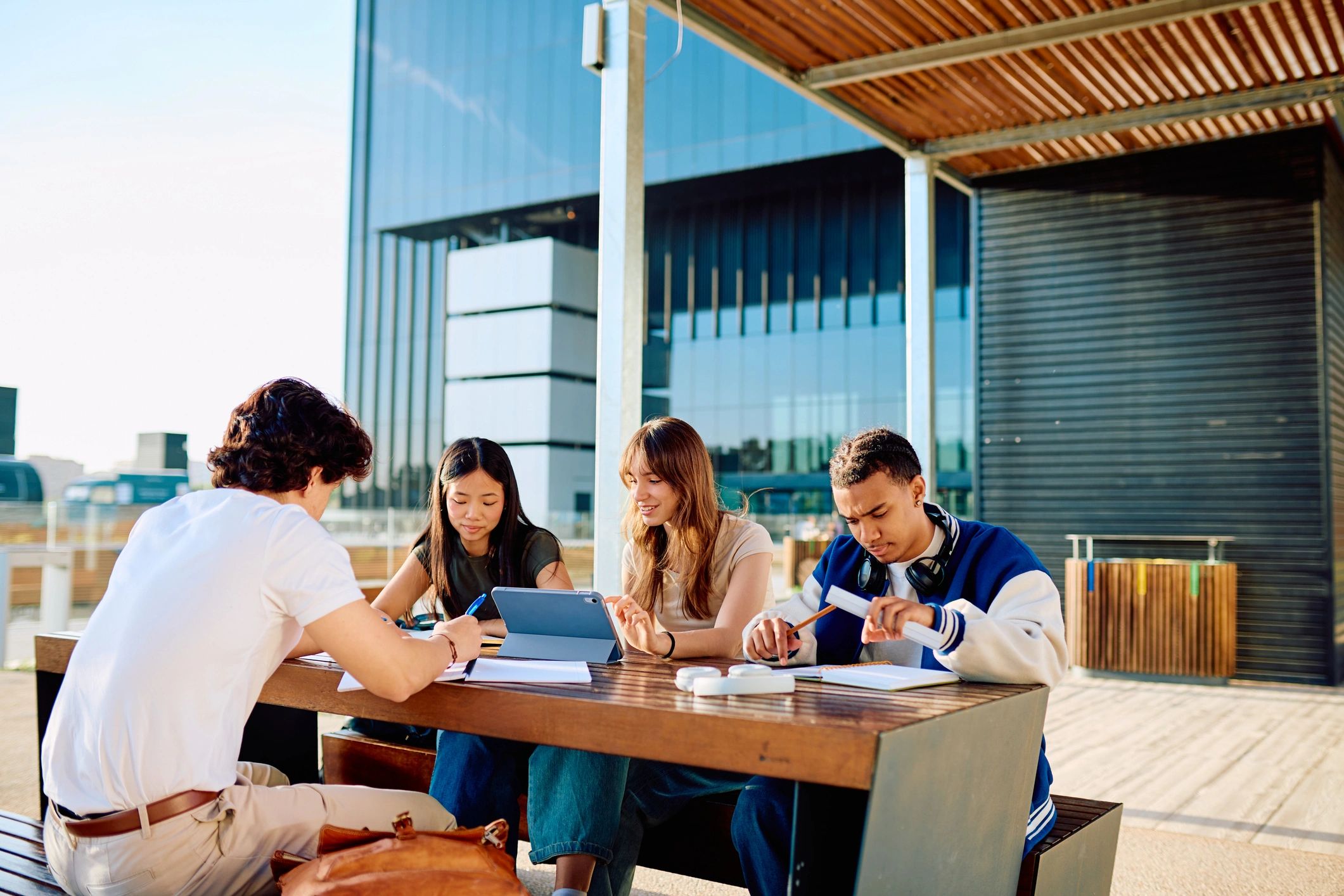 Students studying at an outdoor table on a college campus