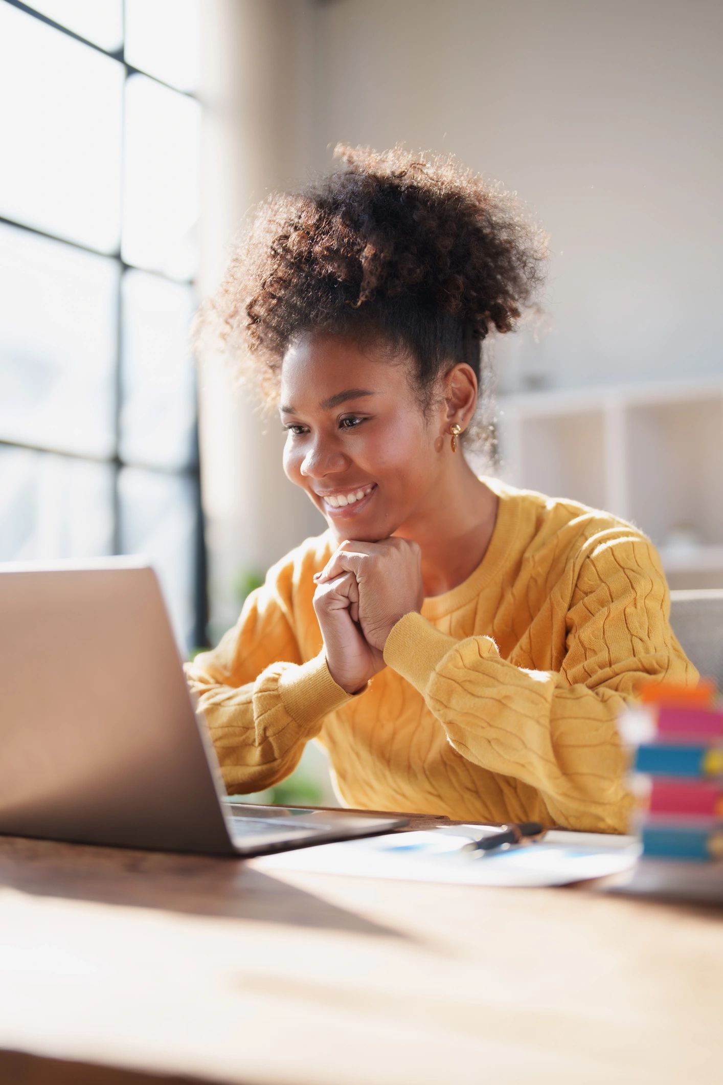 Online student smiling while studying on a laptop at home