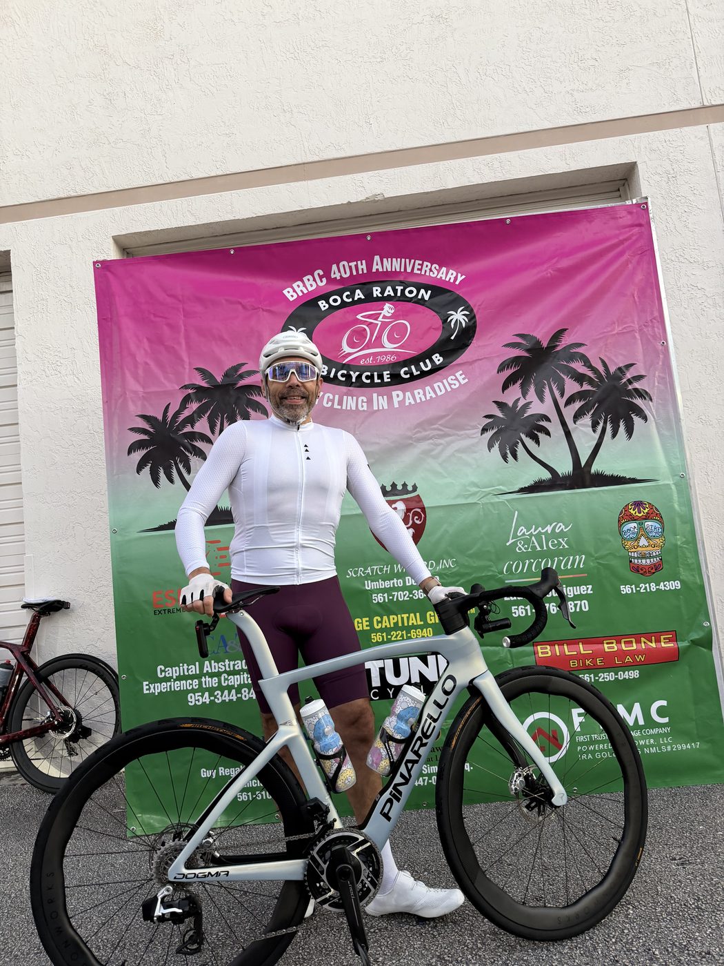 Ricardo with his bike in front of the Boca Raton Bicycle Club 40th Anniversary banner